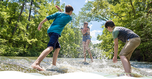 Three kids play in the water while hiking in Kisatchie National Forest.