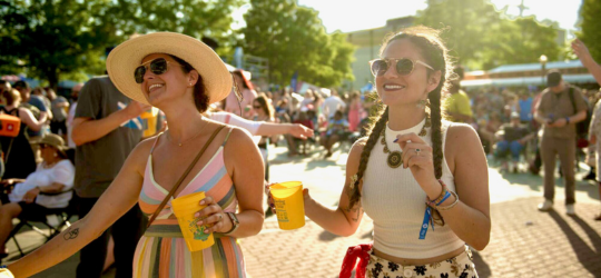 Two women look into the distance as they enjoy a summer festival in Louisiana.