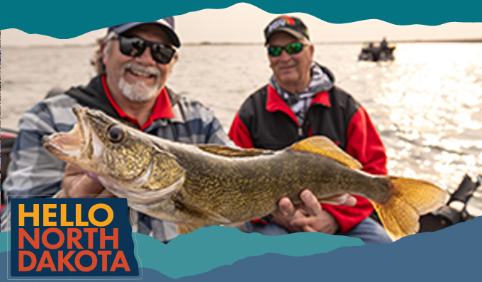 One man holding up a fish with other man in background on a boat. Hello North Dakota logo in bottom left corner. 