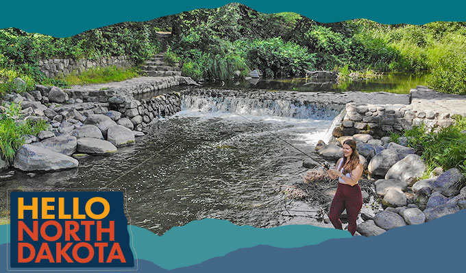 Woman fishing from rocks along a creek with a small waterfall