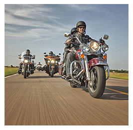 A group of men riding motorcycles on a rural road