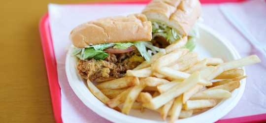 A plate with a po'boy and french fries.