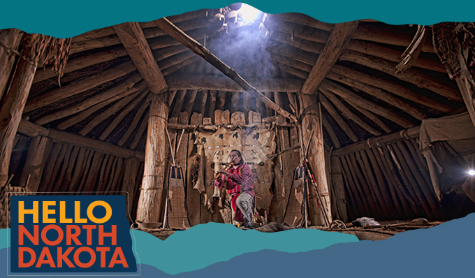 A Native American man in a wooden structure playing a pipe instrument, with overlay text that reads Hello North Dakota
