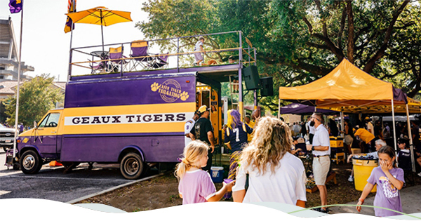 Two people walk toward tailgating area