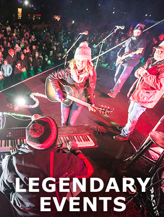 Band wearing winter apparel performing on stage in front of a crowd at night, with overlay text that reads Legendary Events