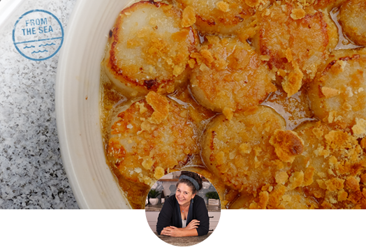 Close up image of baked scallops on a white dish 