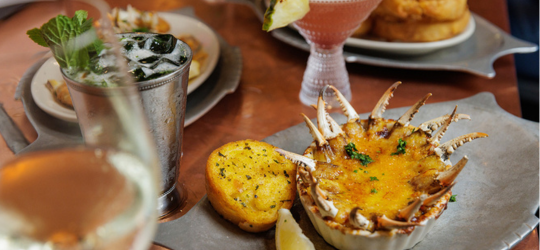 A table with crab claws and cocktails. 