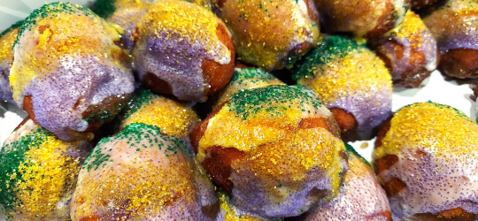 A close up of king cake donut holes.
