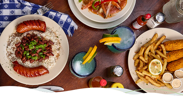 A table full of Louisiana signature dishes, including red beans and rice and fried catfish.