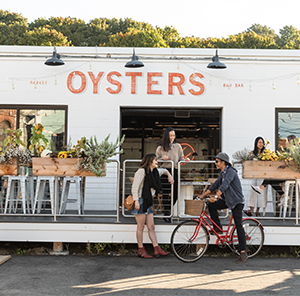 A few friends catching up outside an oyster restaurant. 