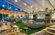 A view of a covered patio area with games, seating and a bar at Aloft Austin Downtown