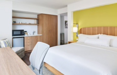 View of a guestroom with a bed, desk and kitchen area at Element Austin Downtown