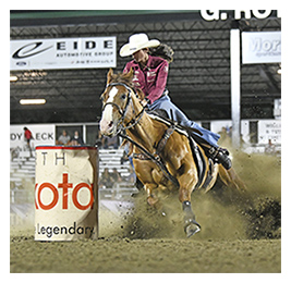 Person riding a horse that's kicking up dirt during a rodeo event