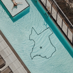 Aerial view of the pool featuring an outline of the state of Texas on the pool floor at AustinPlace 