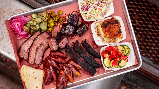 A platter of barbecued meats and sides that include coleslaw from InterStellar BBQ