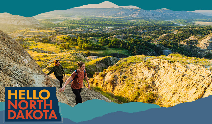 two people hiking around a cliff 