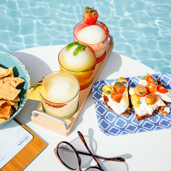 Platters of small bites and frosty drinks poolside at the West Austin Downtown in Austin, Texas