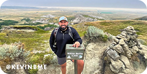 Smiling man on a mountain, with overlay text that reads: @kevinbme