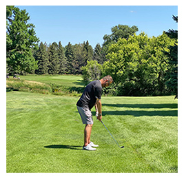 Man preparing to hit a golf ball on a green course