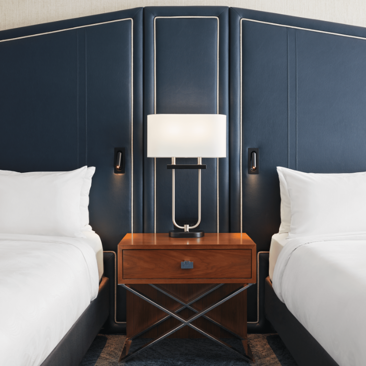 An end table, lamp and headboard between two beds in a room at JW Marriott Austin 