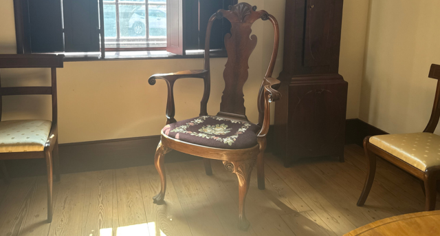 A regal walnut chair with curved lines and an elegant purple and patterned slip seat at the Old State House in Dover.