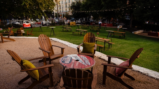 Adirondack chairs surround a table at the Fair Market outdoor venue in Austin, Texas
