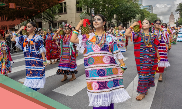 Women dressed in colorful costumes march in the Viva la Vida Festival parade in Austin, Texas