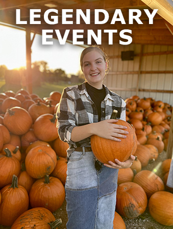 Woman standing in front of a large pile of pumpkins while holding a pumpkin, with overlay text that reads: Legendary Events