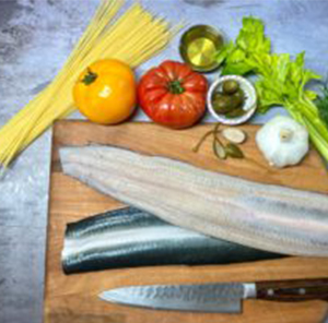 Cutting board with eel surrounded by vegetables 
