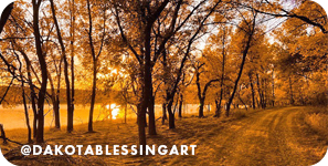 A path surrounded by trees with an orange glow in the air, with overlay text that reads: @dakotablessingart