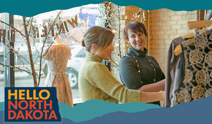 Two women looking at clothes in a store, with overlay text that reads: Hello North Dakota