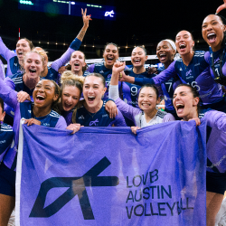 LOVB Austin pro volleyball team members hold a banner and celebrate winning the League One Volleyball championship
