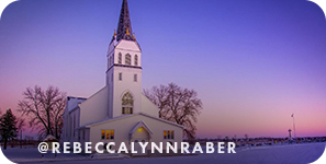 A white chapel with a steeple in a snowy landscape with a purple sky, with overlay text that reads: @rebeccalynnraber