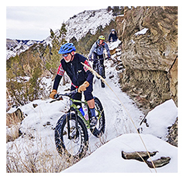 People riding fat-tire bikes on a snowy trail in North Dakota