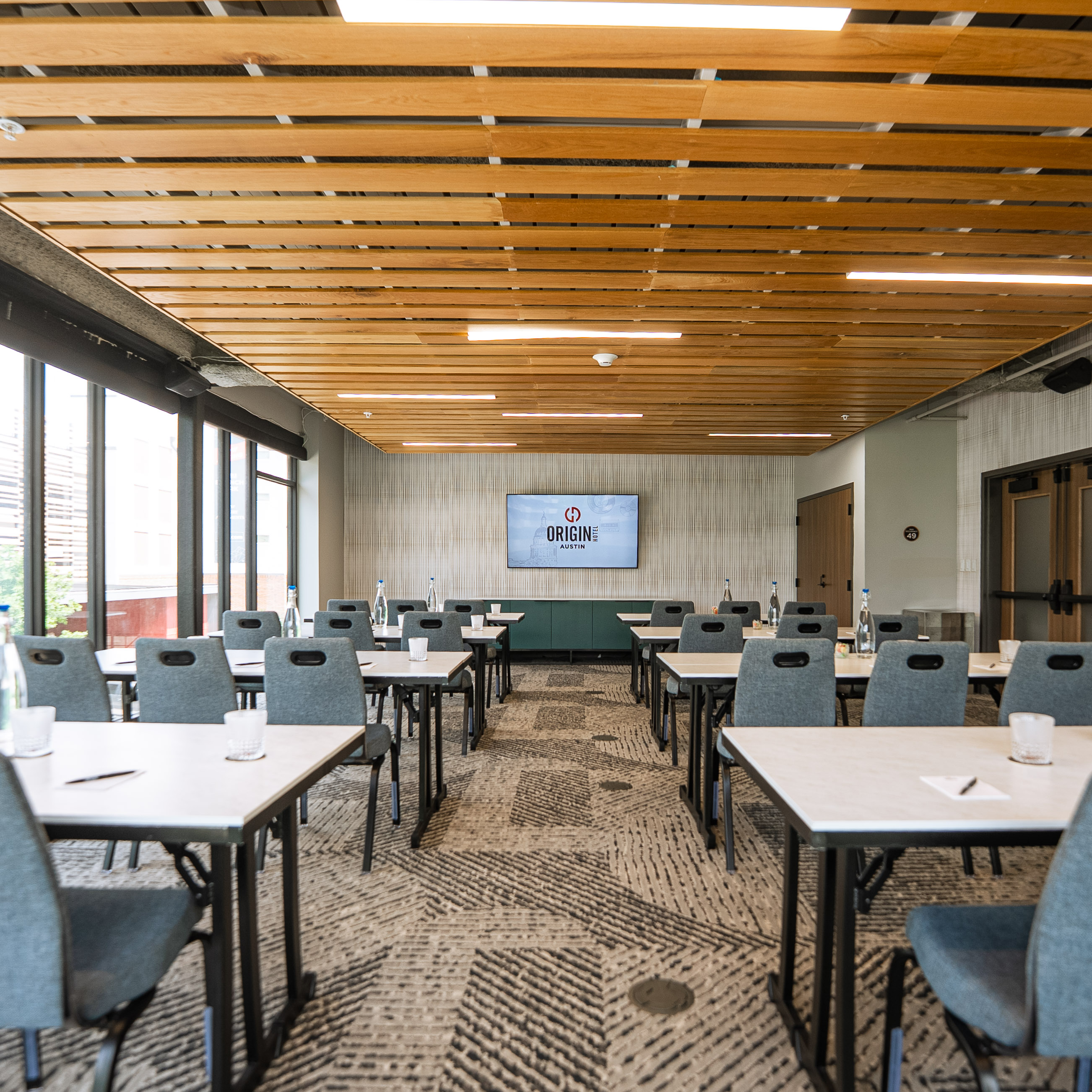 A classroom-style meeting room with floor-to-ceiling windows at the Origin Hotel Austin 