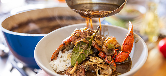 A bowl of seafood gumbo and rice.
