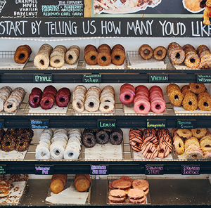 Bakery shelf filled with various different handmade donuts