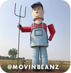 Large statue of a man wearing overalls and holding a pitchfork, with overlay text that reads: @movinbeanz