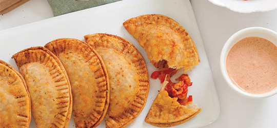 Perfectly golden crawfish hand pies, served with a creamy red sauce.