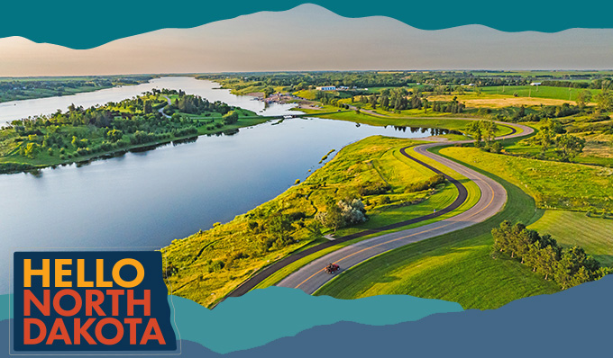 Aerial view of a river, green landscapes and a winding road, with overlay text that reads: Hello North Dakota