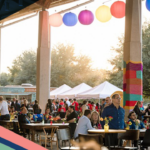A crowd of people networking under a pavilion in Austin, Texas, as part of the NOW & NEXT: A DHL Logistics Summit