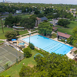 A public swimming pool, tennis courts, plygrounds and green spaces in Rosewood Park in Austin, Texas