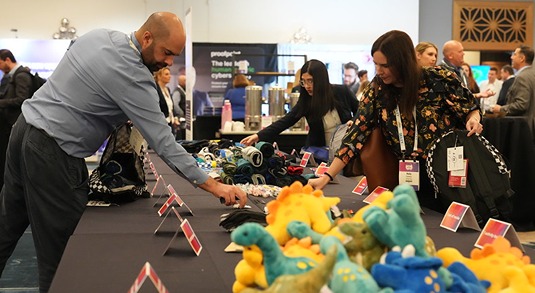 A group of people fill children's backpacks with colorful plush toys at a volunteer event in Austin, Texas