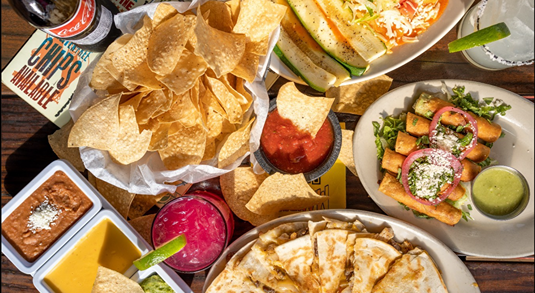 Platters of tortilla chips, salsas, queso, flautas and quesadillas at Maudie’s Tex-Mex in Austin, Texas