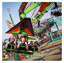 People riding a colorful spinning ride at a fair