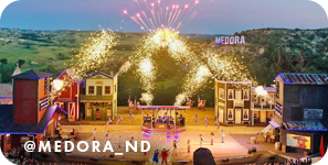 View of a stage production with pyrotechnics overhead, with overlay text that reads: @medora_nd