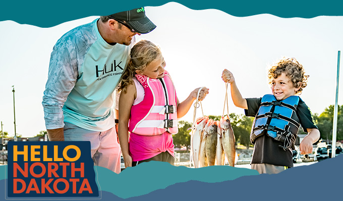 A man and a young girl and boy smiling and holding up caught fish, with overlay text that reads: Hello North Dakota