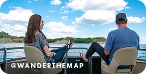 A man and a woman on a boat with their feet up looking at the water, with overlay text that reads: @wanderthemap