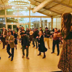 A room filled with people dancing together at an event.