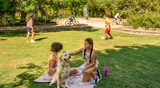 Parkgoers and a dog enjoy soccer, biking and relaxing at Auditorium Shores in Austin, Texas 
